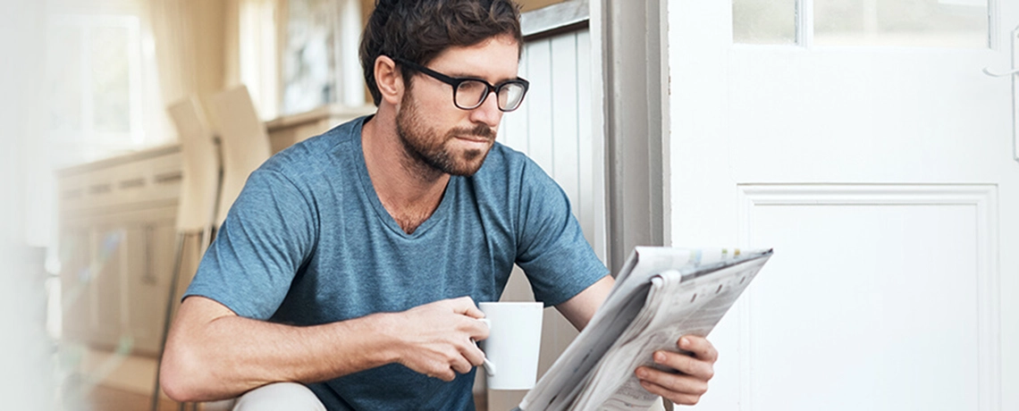 Mann liest die gedruckte Tageszeitung