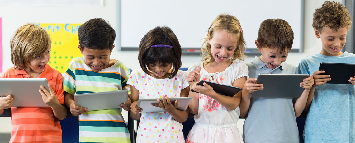 Kinder lesen die digitale Tageszeitung in der Schule